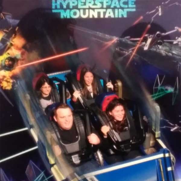 Foto minha e da minha mãe dentro do brinquedo Hyperspace Mountain no parque Disneyland Paris