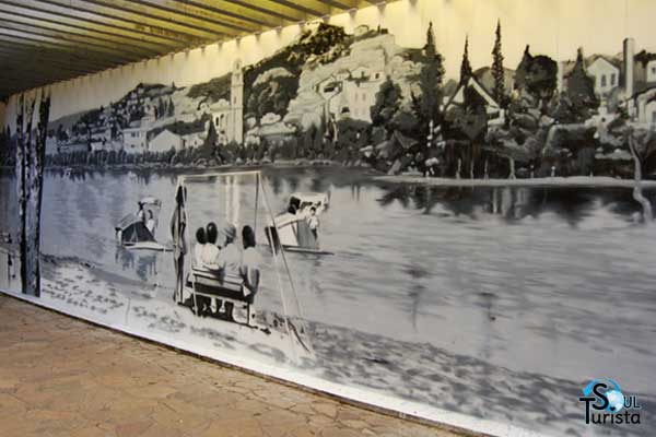 Cena antiga em preto e branco, pintada por Eduardo Kobra no muro do Parque das Águas São Lourenço