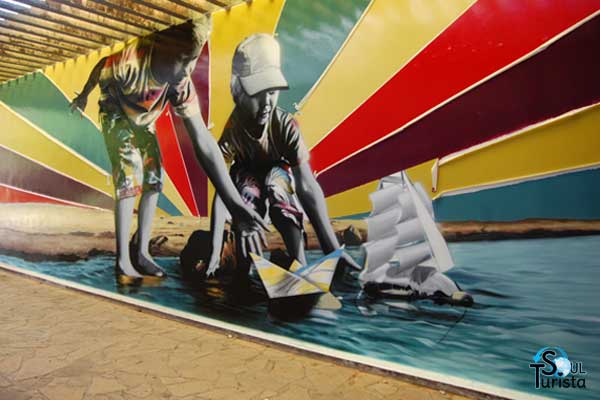 O muro ilustrado por Eduardo Kobra mostra duas crianças brincando com um barquinho na água