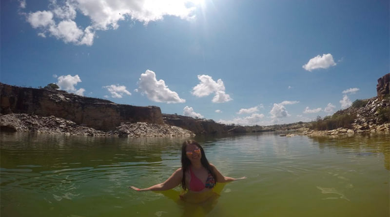 Eu nadando em uma lagoa em Capitólio em um dia ensolarado e de céu azul