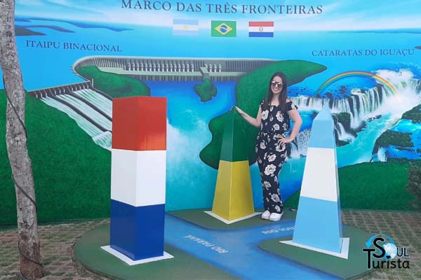 Foto tirada com três obeliscos e cada um deles de uma cor representando a bandeira do seu país, sendo Argentina, Paraguai e Brasil no Marco das Três Fronteiras em Foz do Iguaçu