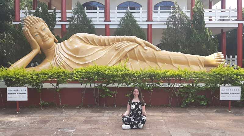 Estátua de Buda em estado de Paranirvana e eu sentada em posição de meditação logo abaixo