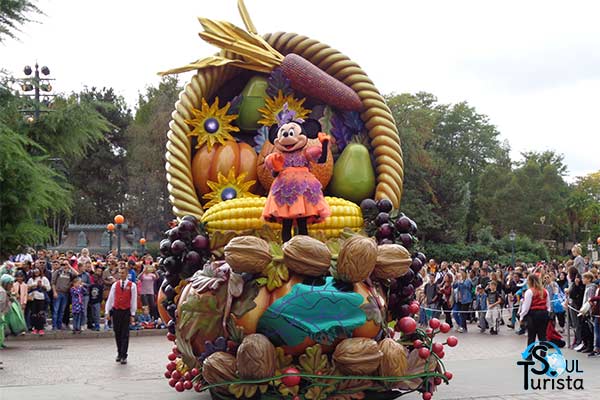 Minnie desfilando em cima do carro alegórico usando um vestido laranja de Halloween