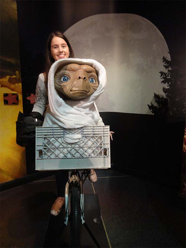 Eu na bicicleta famosa do filme E.T Extraterrestre. Na carona da bicicleta está o personagem ET e ao fundo está a lua