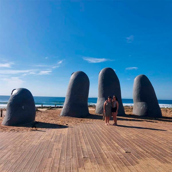 Eu e minha mãe em frente ao Monumento Los Dedos em Punta del Este. Ao fundo está o mar da Playa Brava
