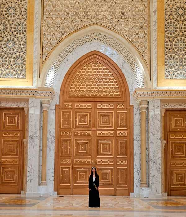 Uma das atrações mais imperdíveis do bate e volta para Abu Dhabi. Eu na frente de uma porta enorme de aproximadamente 10 metros toda feita de ouro